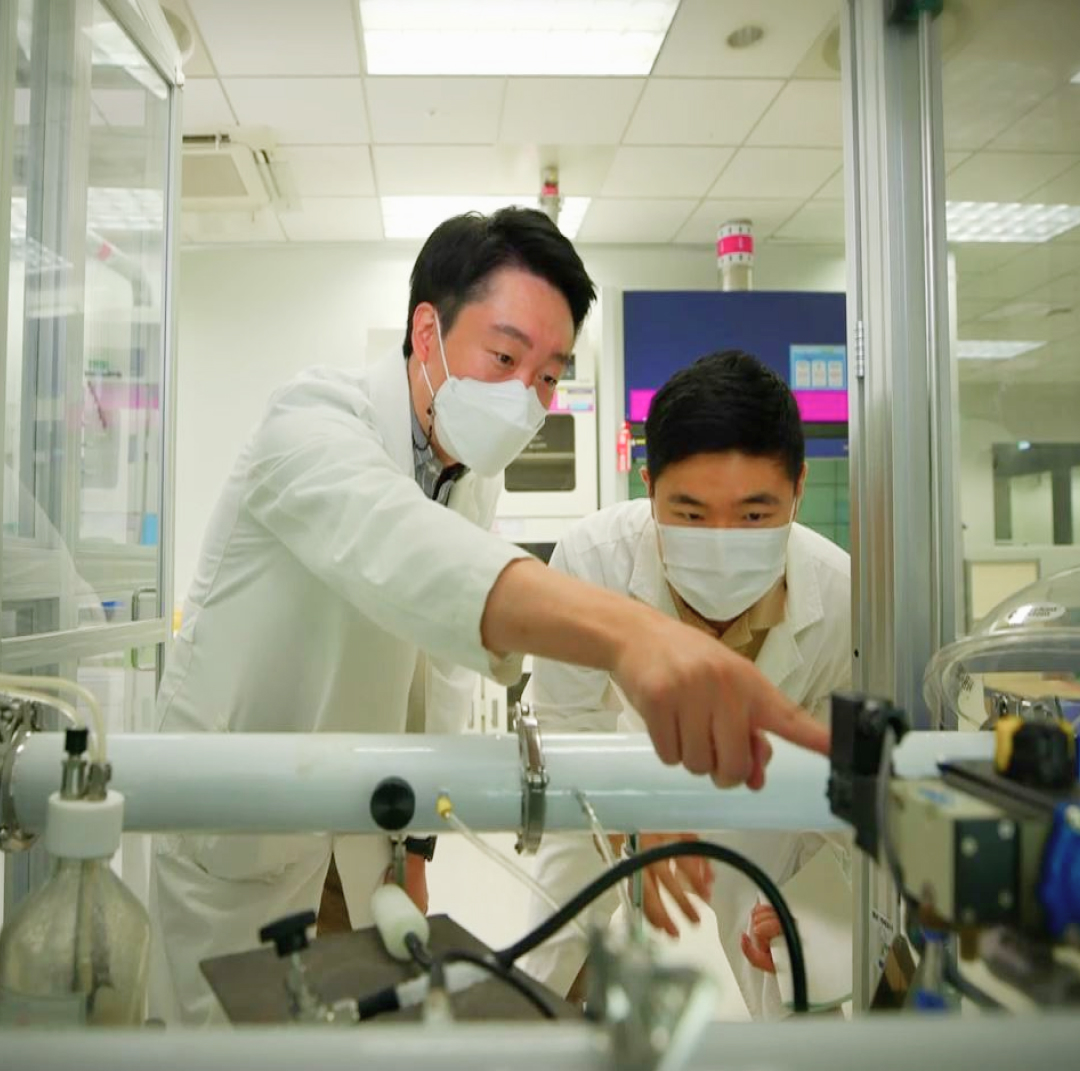 두 명의 연구원이 미세먼지 저감 시스템을 관찰하는 모습